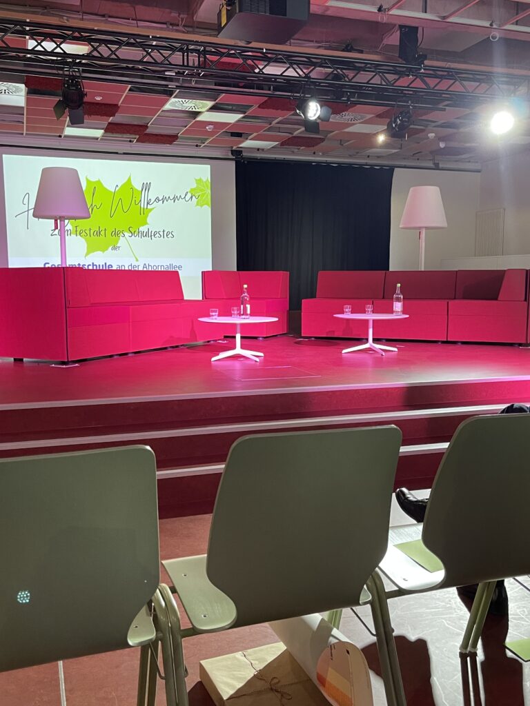 Eine Gruppe von Stühlen in einem Raum mit einer Projektionsfläche.