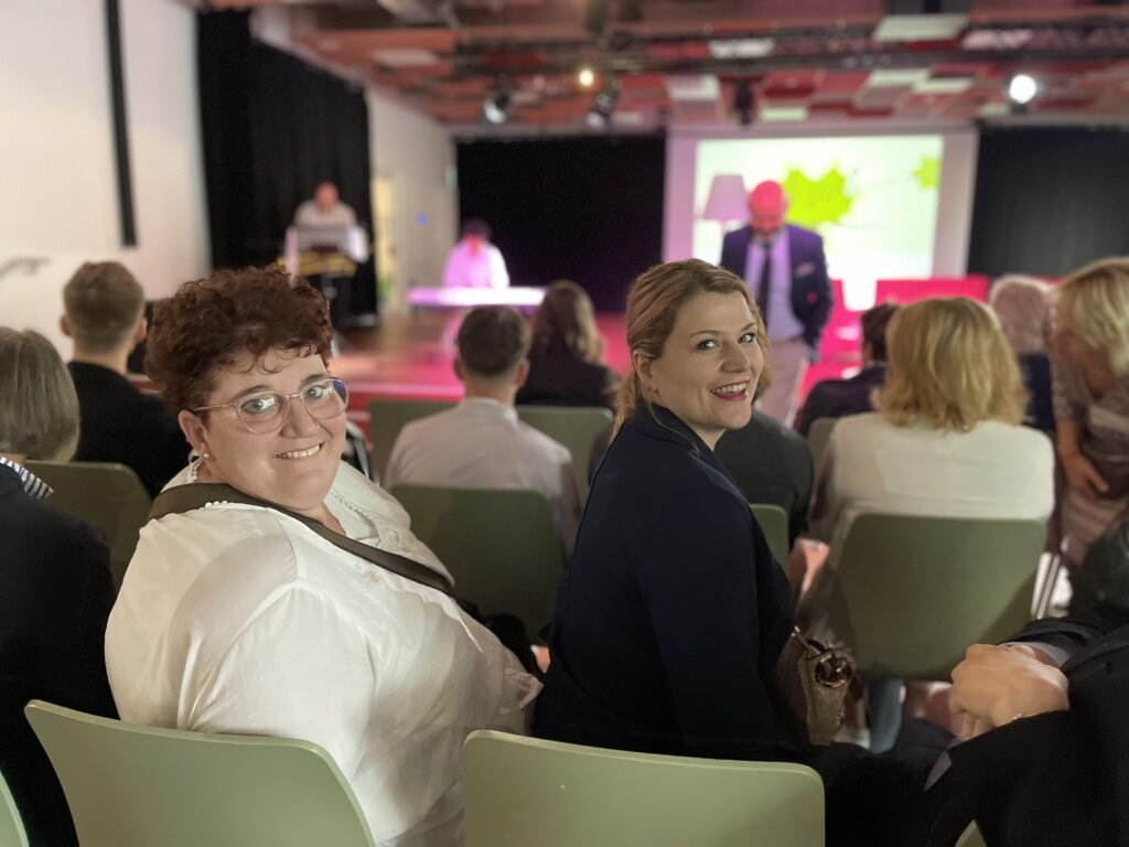 Eine Gruppe von Menschen sitzt auf Stühlen bei einer Konferenz.
