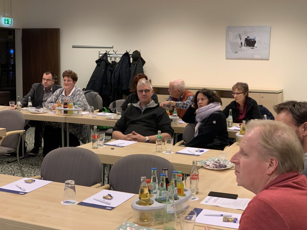 Eine Gruppe von Menschen sitzt um einen Tisch in einem Konferenzraum.