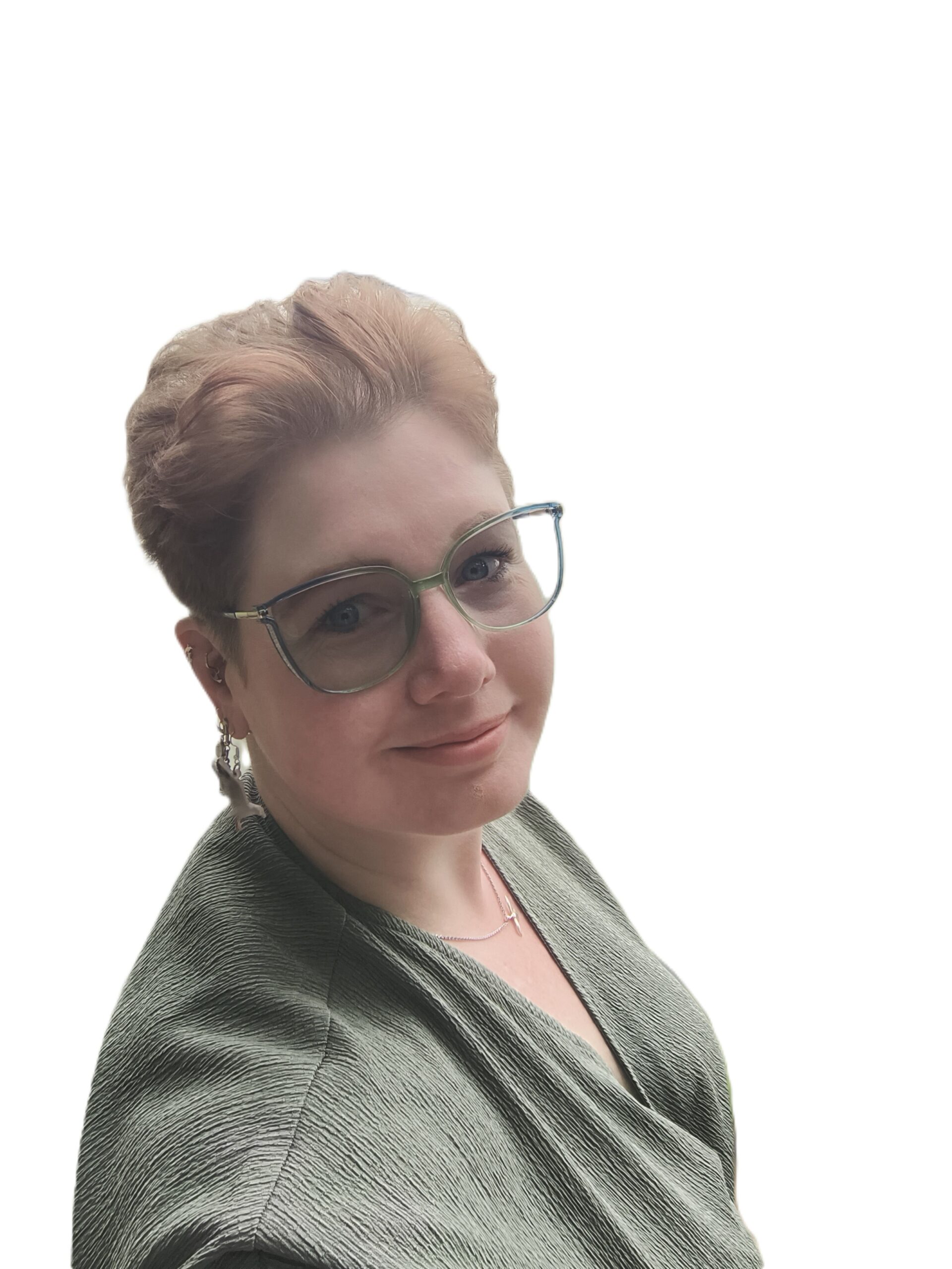 Eine Person mit kurzen hellen Haaren, Brille und Ohrringen, die ein grünes strukturiertes Oberteil trägt, posiert vor einem schlichten weißen Hintergrund.